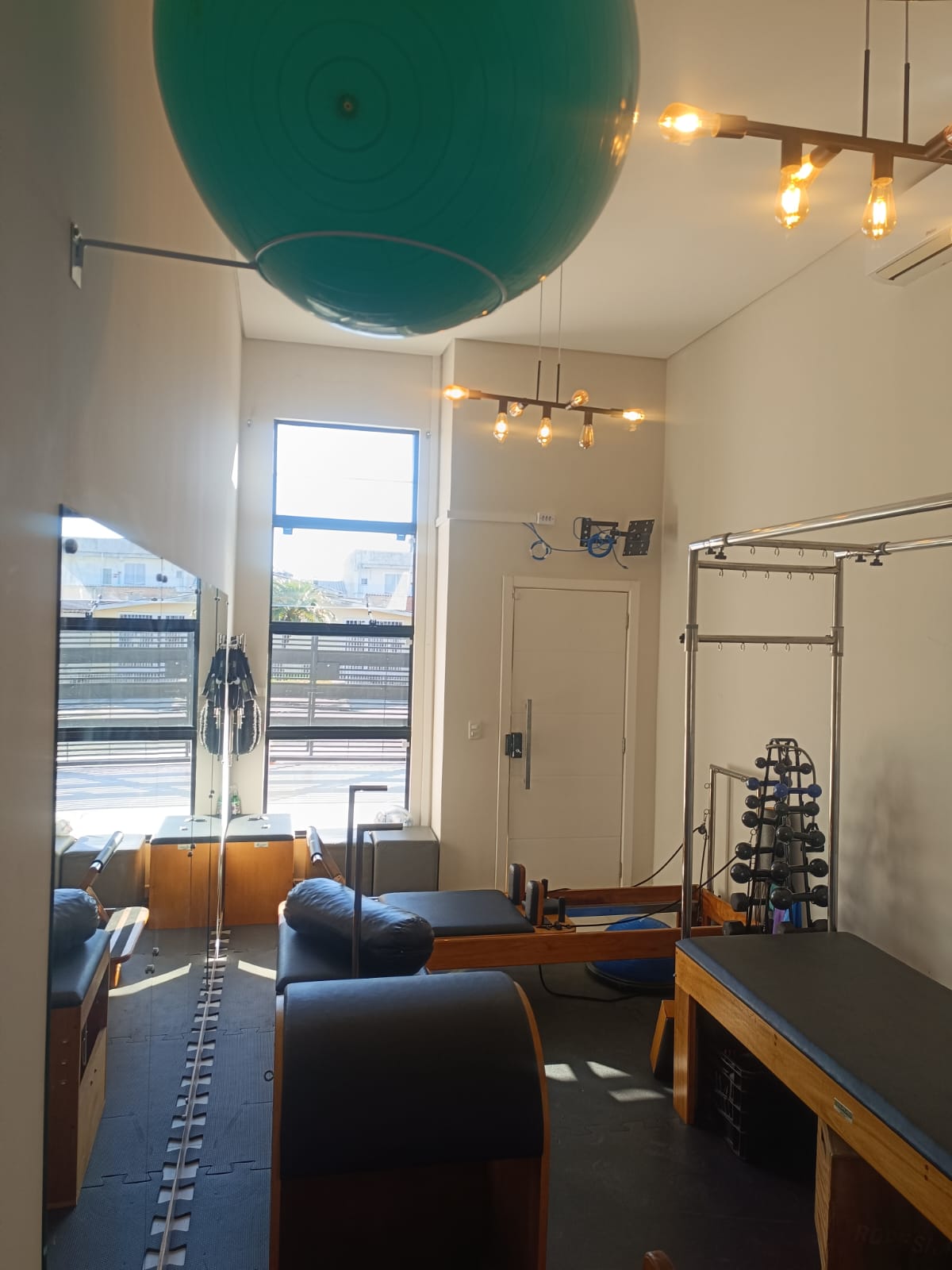 Sala iluminada com reformers no Polo Pilates